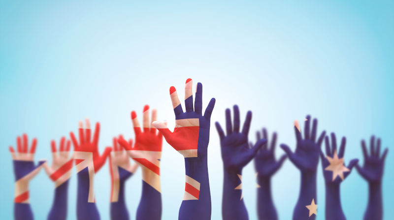 National flag on people open palm hands raising in the air isolated on blue sky background.