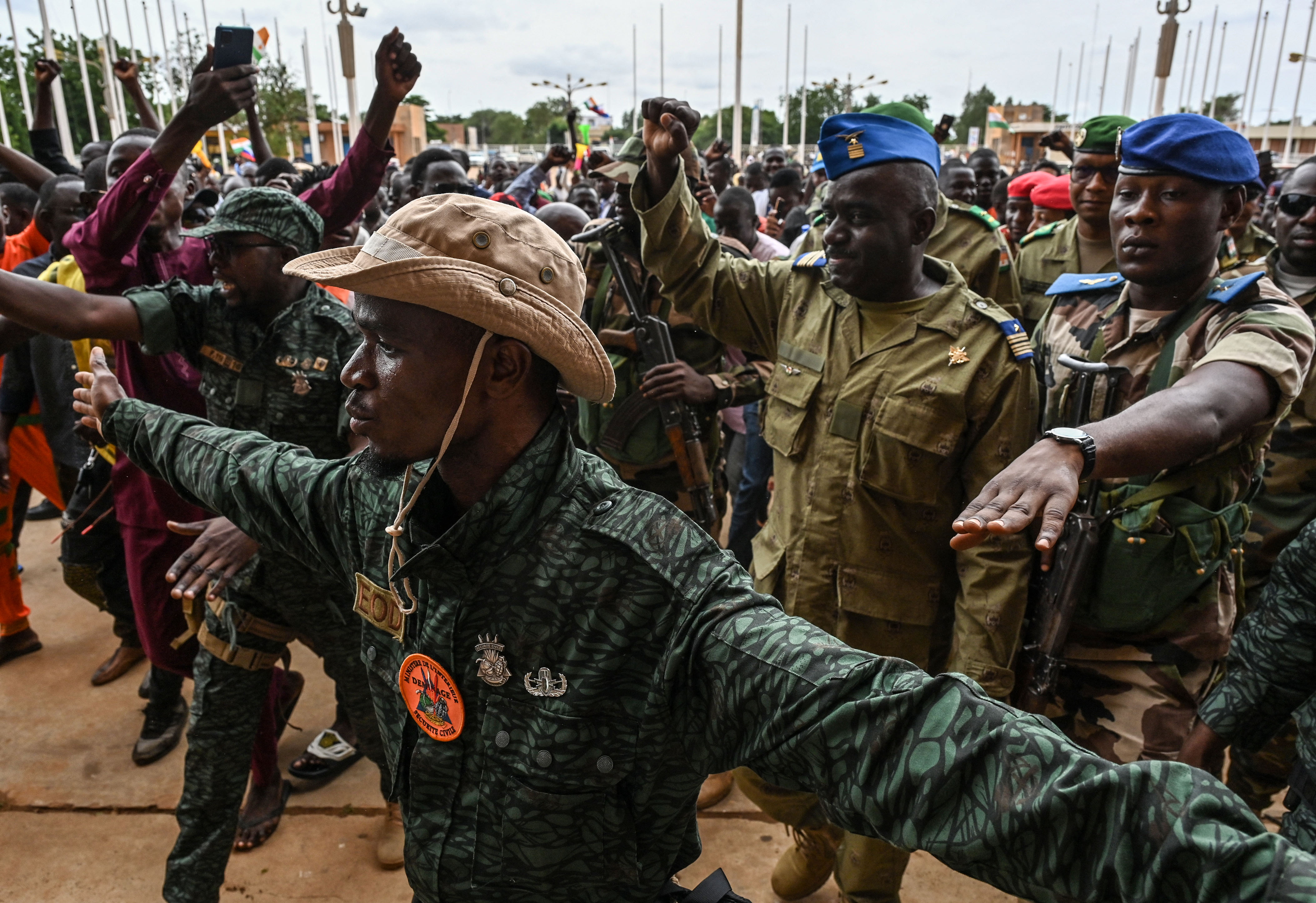 TOPSHOT - Niger's National Council for the Safeguard of the Homeland (CNSP) Colonel-Major Amadou Abdramane (2nd R) is greeted by supporters upon his arrival at the Stade General Seyni Kountche in Niamey on August 6, 2023. Thousands of supporters of the military coup in Niger gathered at a Niamey stadium Sunday, when a deadline set by the West African regional bloc ECOWAS to return the deposed President Mohamed Bazoum to power is set to expire, according to AFP journalists. A delegation of members of the ruling National Council for the Safeguard of the Homeland (CNSP) arrived at the 30,000-seat stadium to cheers from supporters, many of whom were drapped in Russian flags and portraits of CNSP leaders. (Photo by AFP) / "The erroneous mention[s] appearing in the metadata of this photo by - has been modified in AFP systems in the following manner: [Colonel-Major Amadou Abdramane] instead of [Colonel-Major Amadou Adramane]. Please immediately remove the erroneous mention[s] from all your online services and delete it (them) from your servers. If you have been authorized by AFP to distribute it (them) to third parties, please ensure that the same actions are carried out by them. Failure to promptly comply with these instructions will entail liability on your part for any continued or post notification usage. Therefore we thank you very much for all your attention and prompt action. We are sorry for the inconvenience this notification may cause and remain at your disposal for any further information you may require." (Photo by -/AFP via Getty Images)