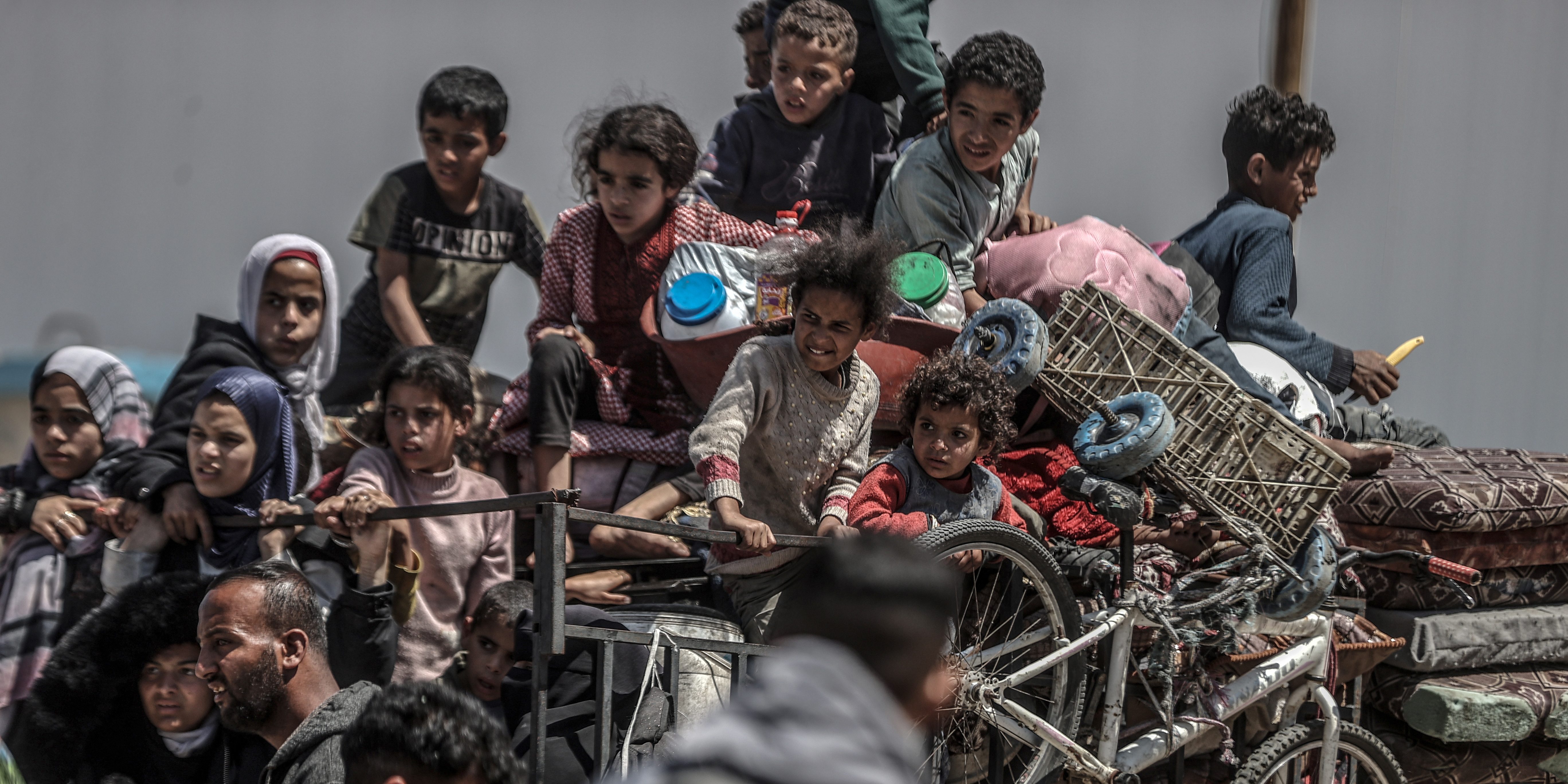 RAFAH, GAZA - MAY 8: Children sit back on a truck as Palestinians with their packed belongings, continue to depart from the eastern neighborhoods of the city due to ongoing Israeli attacks in Rafah, Gaza on May 8, 2024. (Photo by Ali Jadallah/Anadolu via Getty Images)