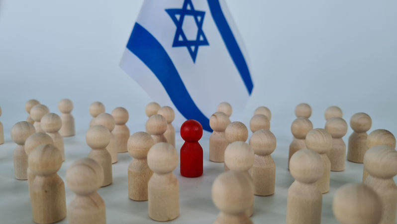 Group of people figurines and small flags of Israel. Red special man to the crowd
